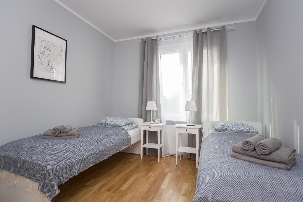 sypialnia z 2 łóżkami i oknem w obiekcie CR Apartament Centrum Zamenhofa 1 w mieście Białystok