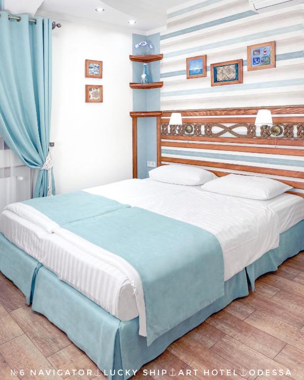 a bedroom with a large bed with blue and white stripes at Lucky Ship Art Hotel in Odesa