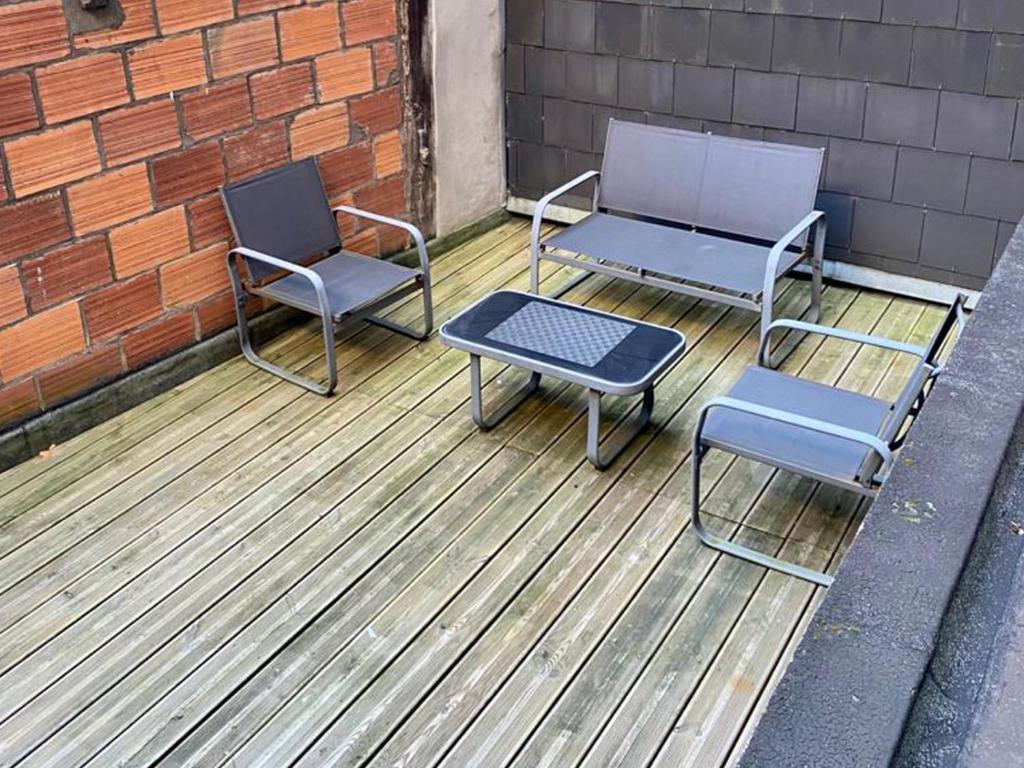 two chairs and a table on a wooden deck at Studio avec toit terrasse privé, en centre ville - 004 in Rouen