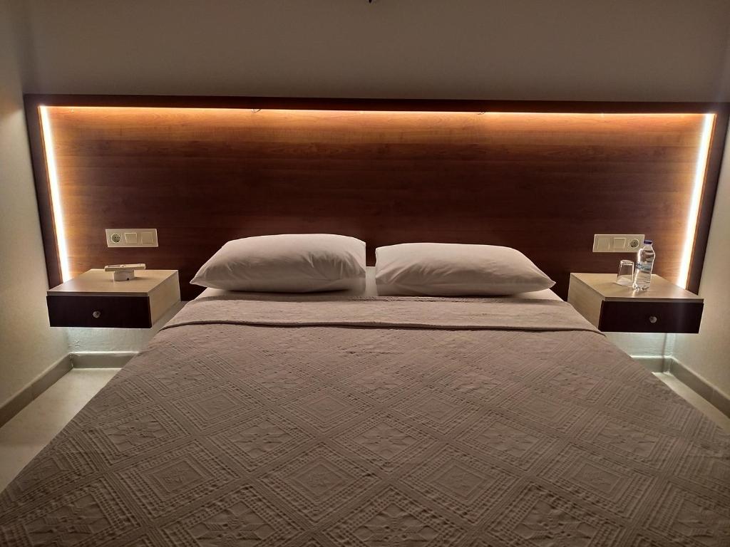 a bedroom with a large bed with two night stands at Olympos Yavuz Hotel in Cıralı