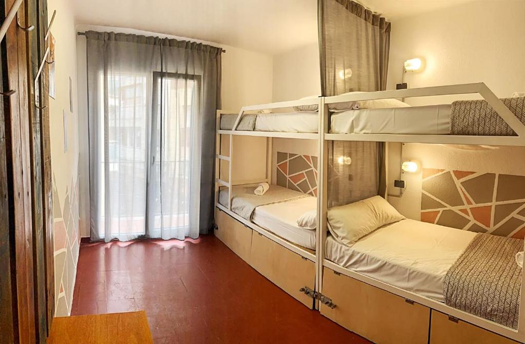 リョレート・デ・マルにあるApartments centro Lloret para 6の窓付きの客室で、二段ベッド2台が備わります。