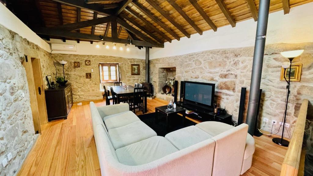 a living room with a white couch and a tv at Casa da Avó in Arcos de Valdevez