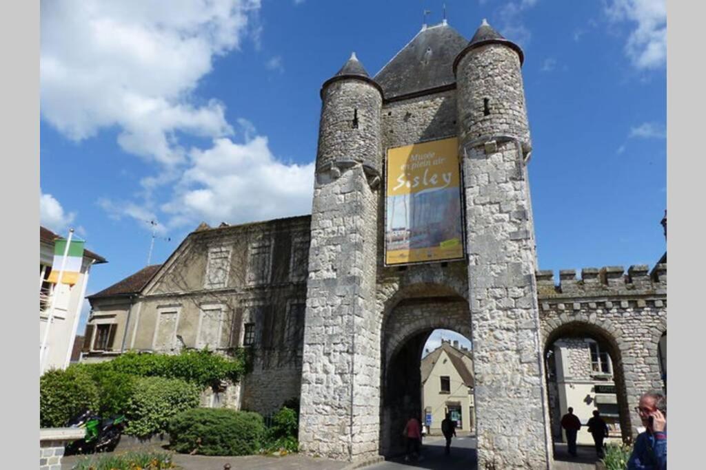 an old stone building with an arch in front of it at Studio de la porte de Samois in Moret-sur-Loing