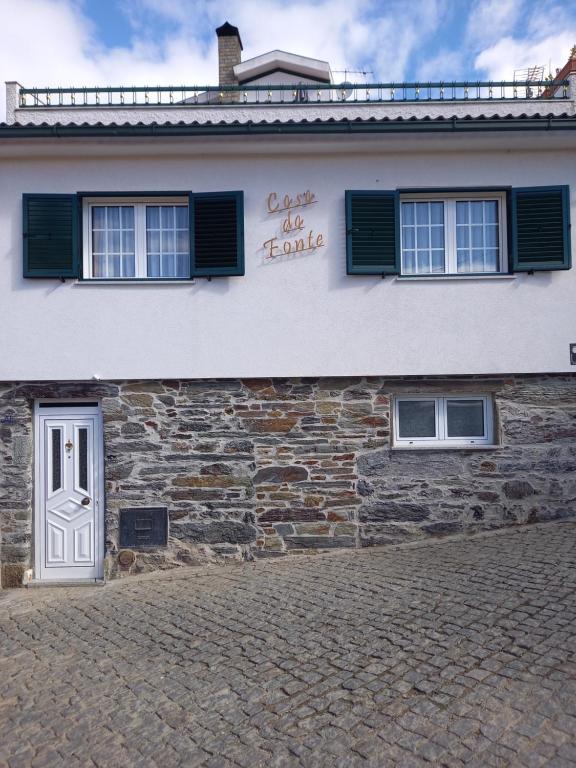 ein Steingebäude mit einem Schild an der Seite in der Unterkunft Casa da Fonte in Peso da Régua