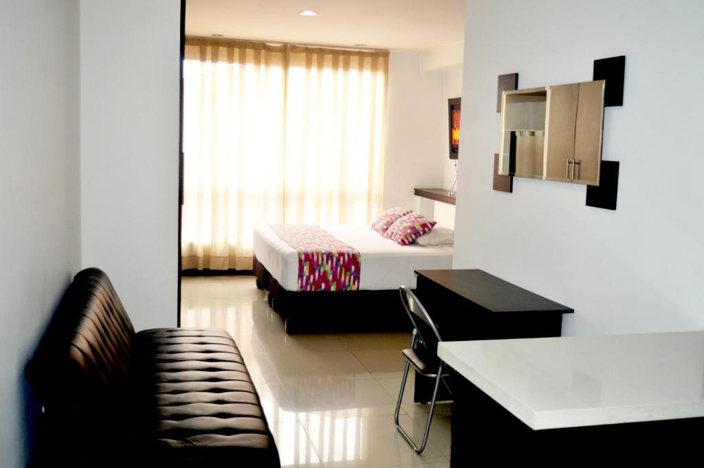 Hotel Mare Apartasuite في كالي: غرفة نوم بسرير وكرسي في غرفة