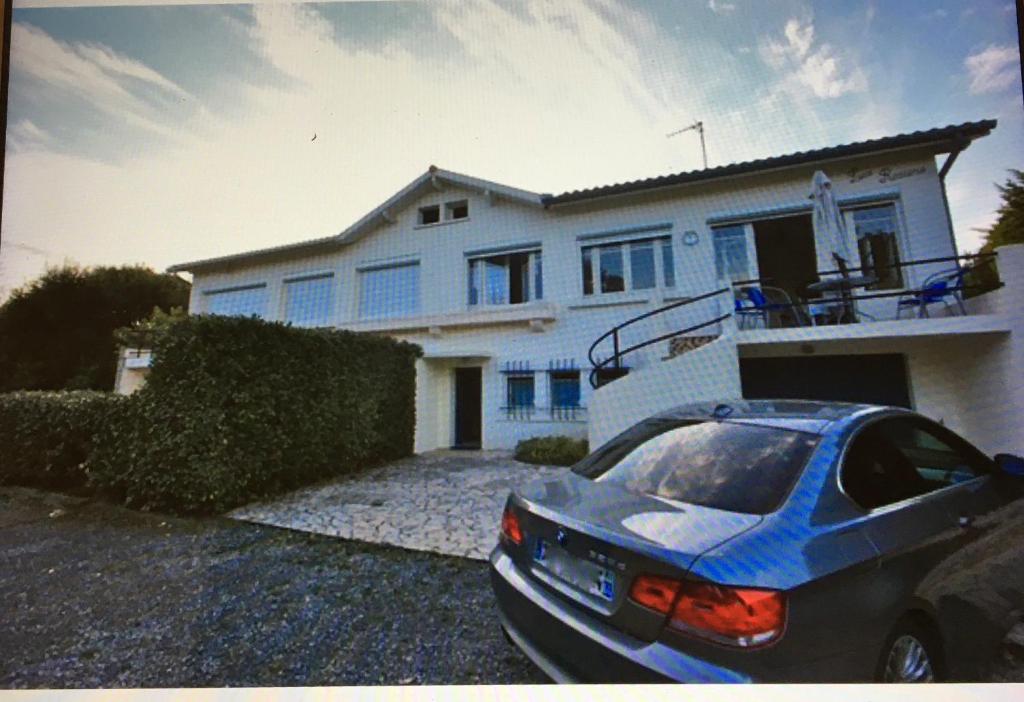 une voiture bleue garée devant une maison dans l'établissement Villa CAPBRETON 5 personnes, à Capbreton