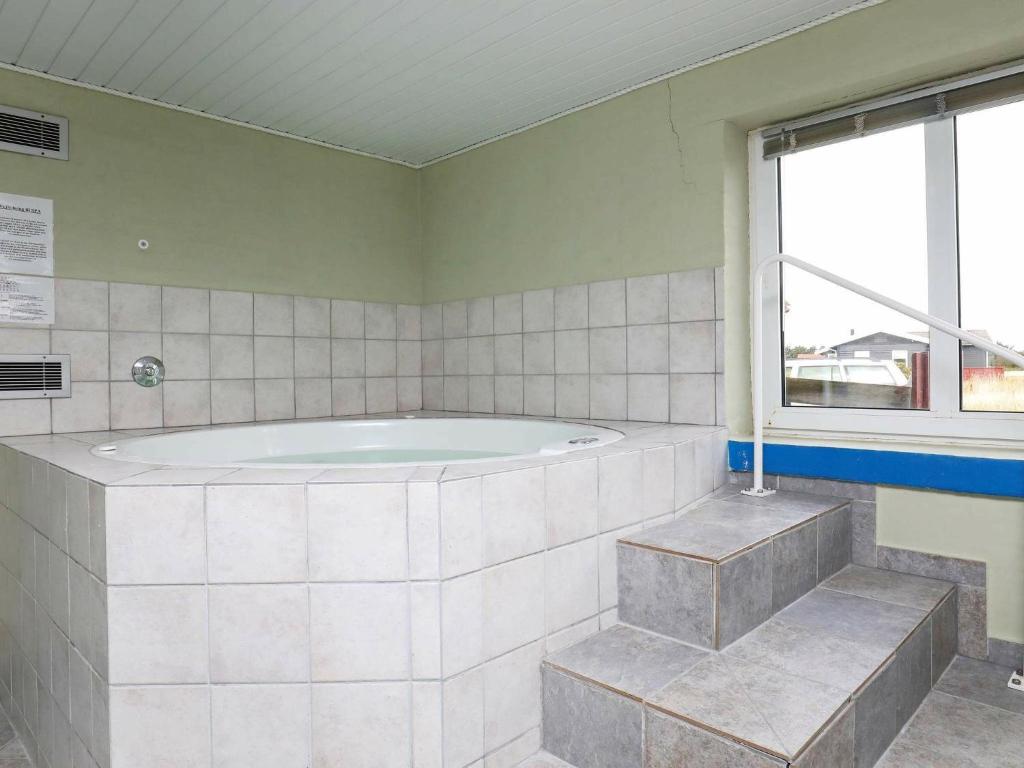 a large bathroom with a tub and a window at 10 person holiday home in Harbo re in Harboør