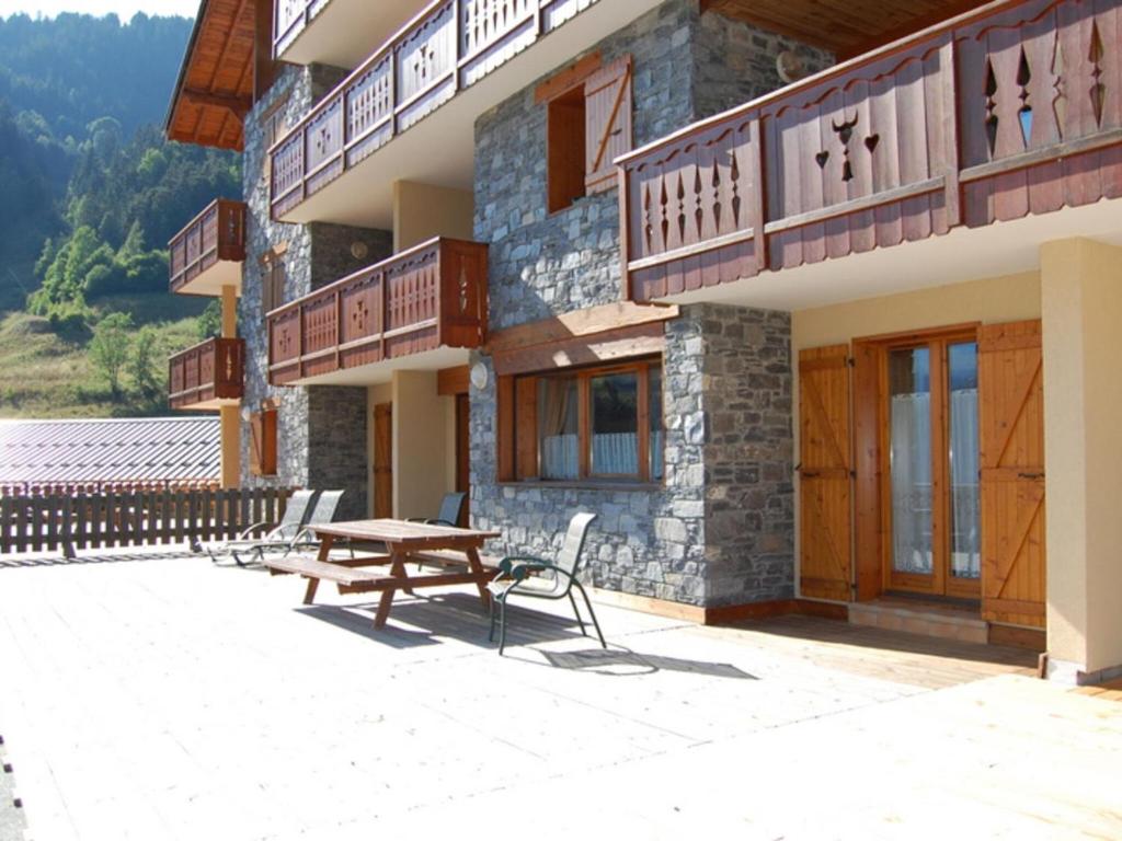 a building with a wooden table and a bench at Beautiful south facing chalet in Le Villard