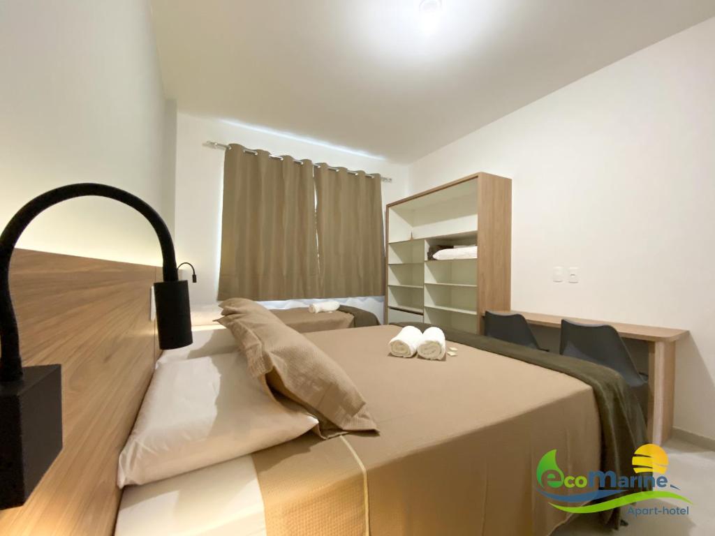 um quarto com uma cama com duas toalhas em Ecomarine Apart-hotel 800 m Beto Carrero em Penha