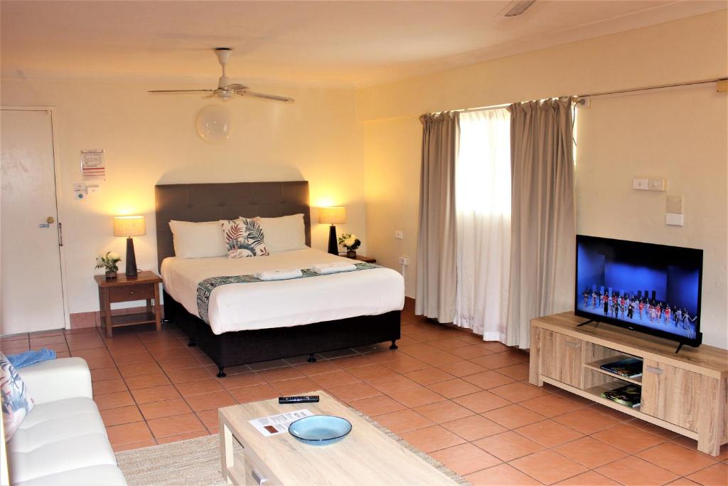 a living room with a bed and a tv at Lake Central Cairns in Cairns