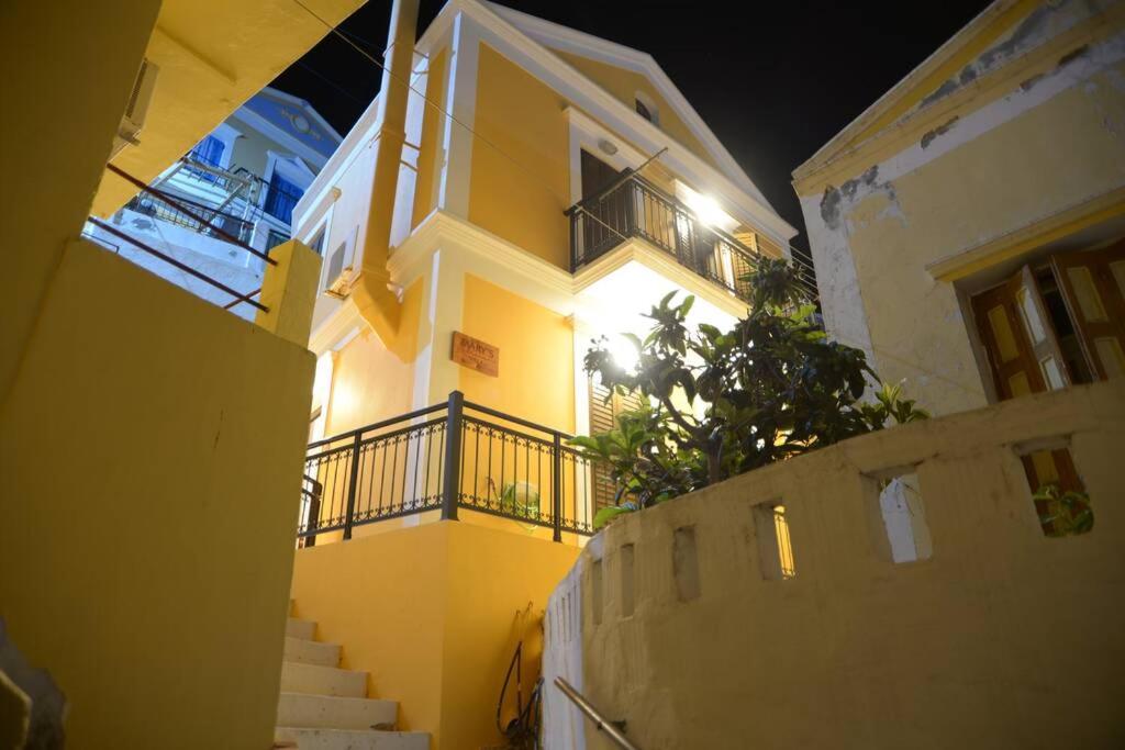 a yellow and white building with stairs and a balcony at Mary's dreams Villa in Symi