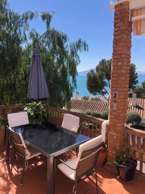 a patio with a table and chairs and an umbrella at A home-from-home with stunning views fibre-optic broadband + UK and Spanish TV in Málaga