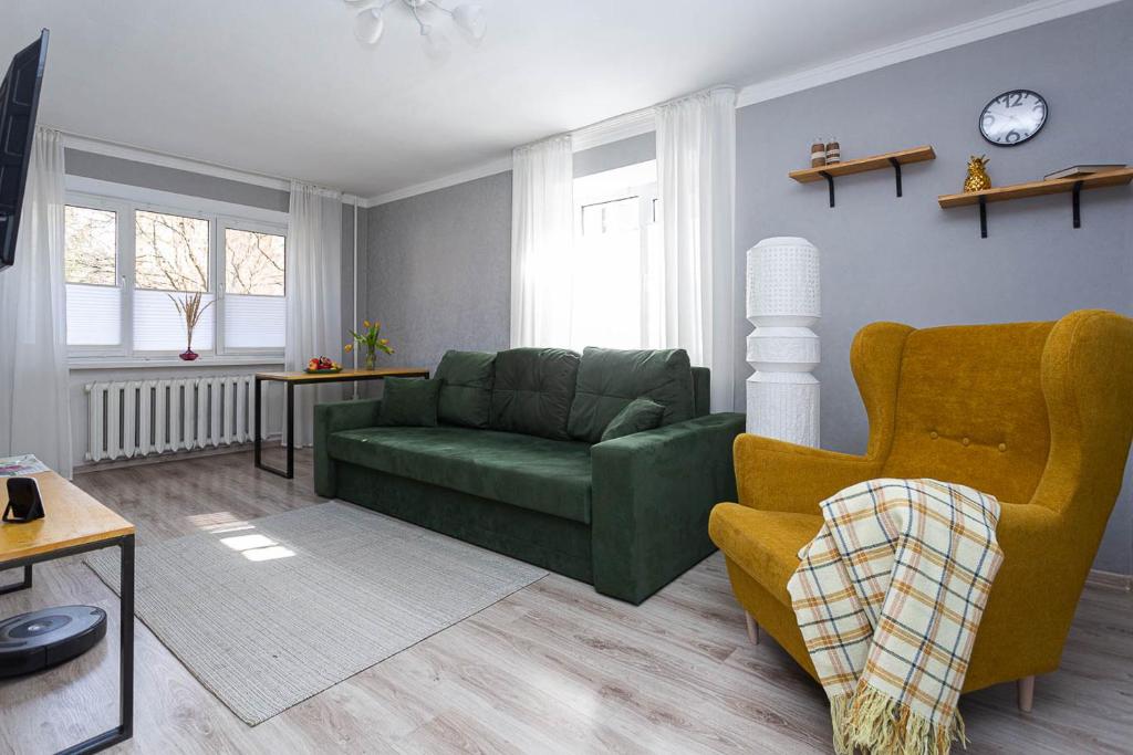 a living room with a green couch and a chair at Apartment in the Center Gray Garden in Kaliningrad