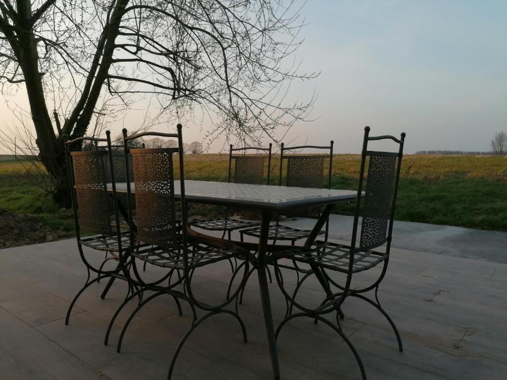 einen Tisch und vier Stühle um einen Tisch herum in der Unterkunft Maison du Pré à 2 pas de Pairi Daiza in Brugelette