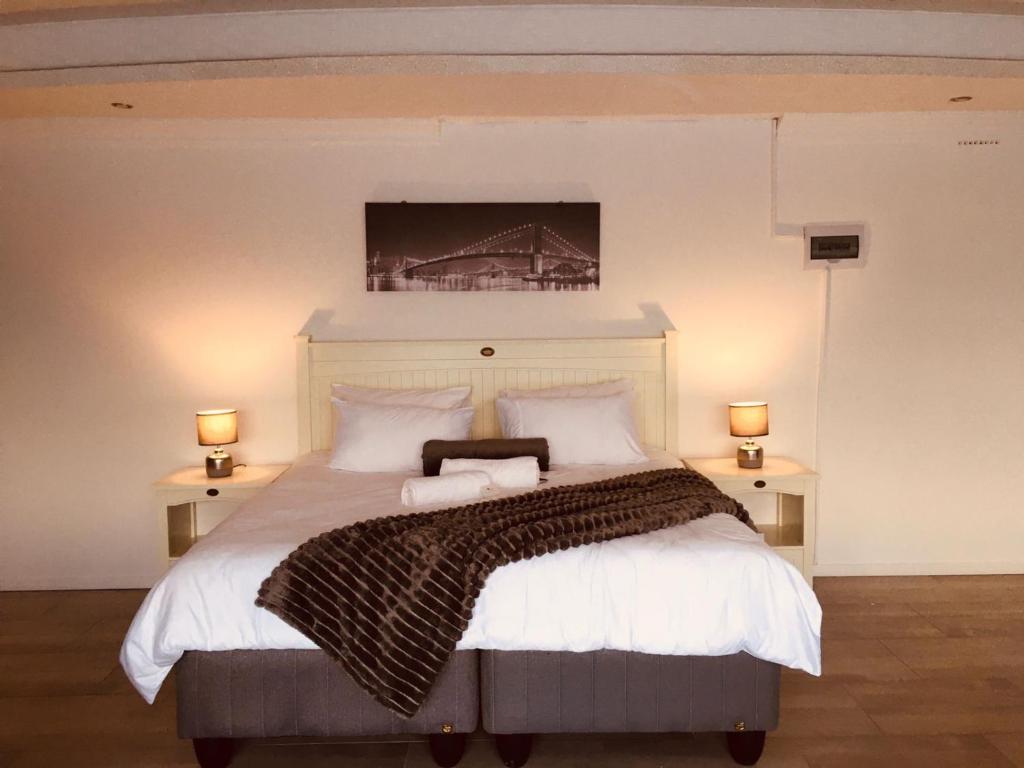 a bedroom with a large bed with a painting on the wall at Omaha Luxury B&B/Spa in Mthatha