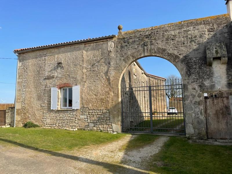 un antiguo edificio de piedra con una puerta delante de él en La Commanderie des Templiers Gîte 4 étoiles en Saint-Étienne-de-Brillouet