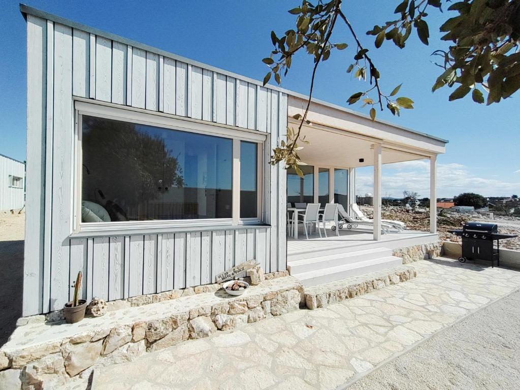 ein Haus mit einem großen Fenster an der Seite in der Unterkunft Camp Buqez 45 - Villa Artica in Pakoštane