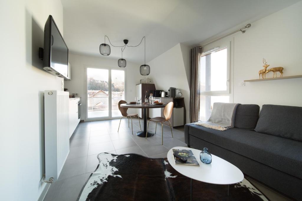 sala de estar con sofá y mesa en LES MYRTILLES Aix les Bains, en Aix-les-Bains