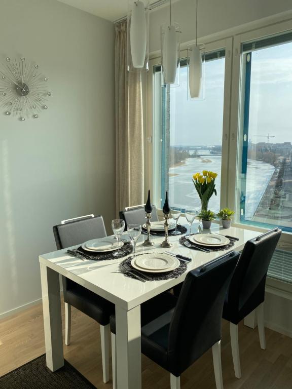 a dining room with a white table and chairs at The River 31, Baritoni in Pori