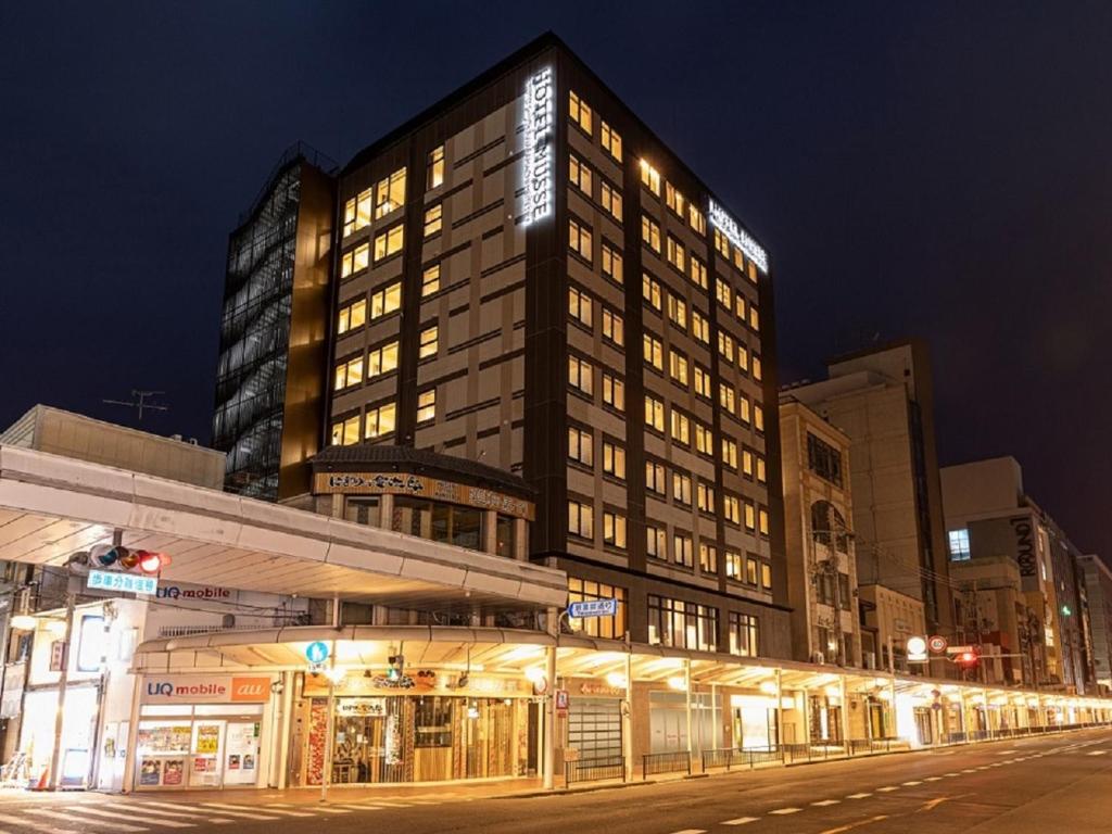 京都市にあるホテルミュッセ京都四条河原町名鉄の夜の街灯が灯る高層ビル