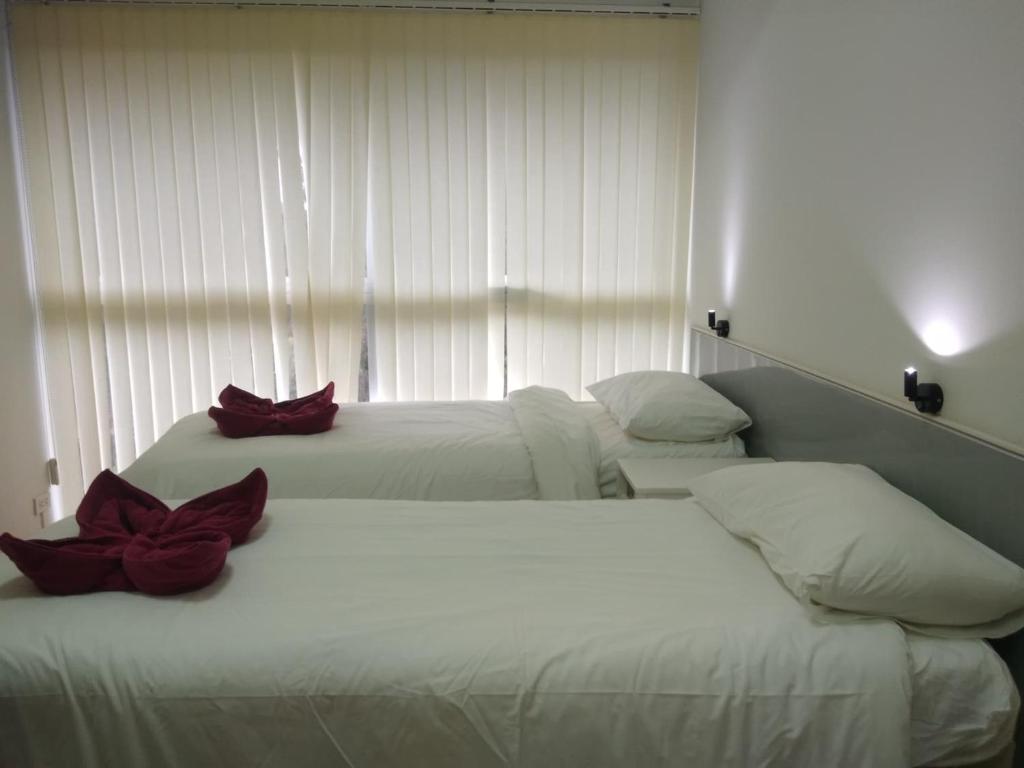 two beds in a hotel room with red flowers on them at Avatara condo A63 by malai in Ban Tha Fat