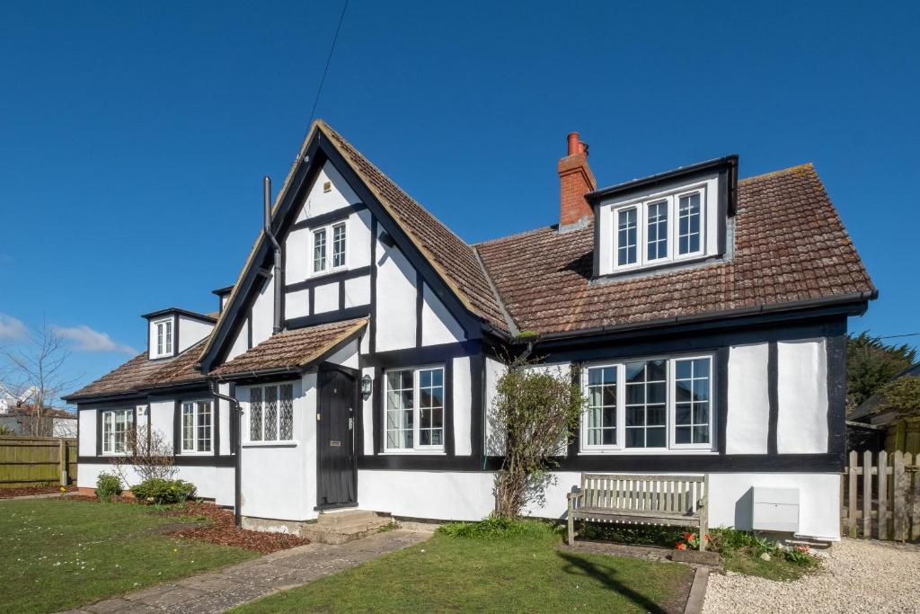 a black and white house with a bench at 6 Lakeside Avenue in Thorpeness