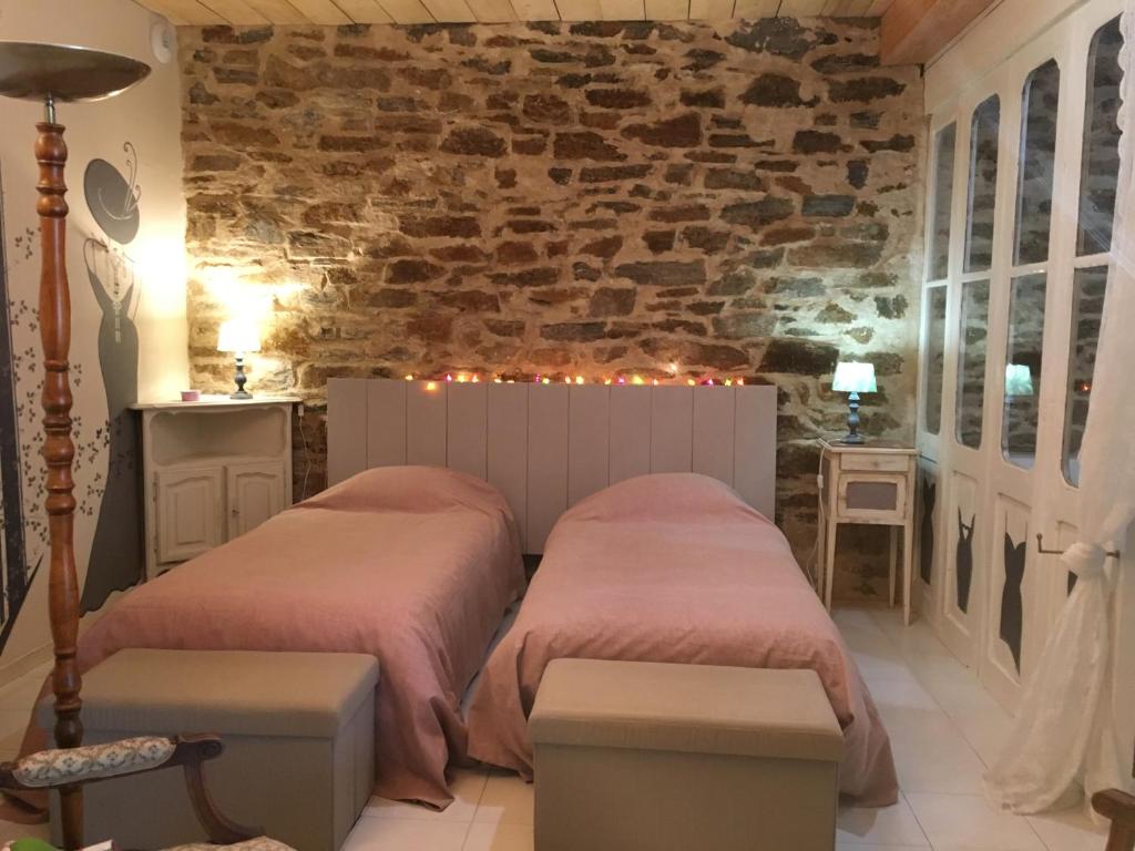 two beds in a room with a brick wall at Le roc de l&#39;aigle in Cabrespine