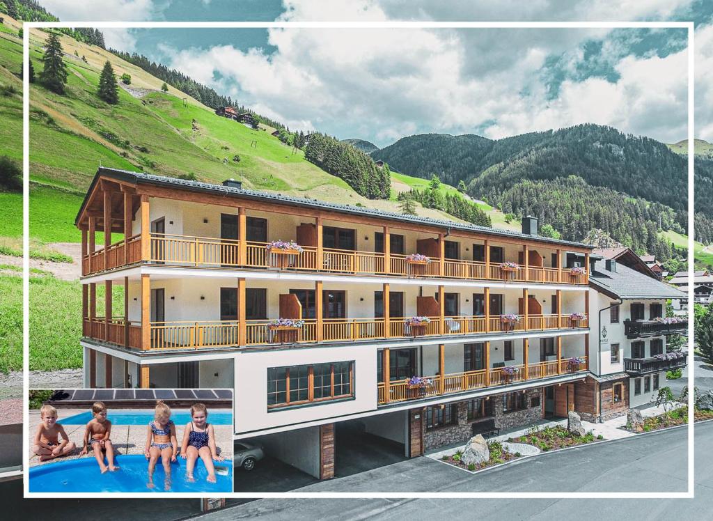 ザンクト・ヤーコプ・イン・デフェルエッゲンにあるTyrol Mountain Aparts - Urlaubsresort Hafeleの大きな建物の正面にプールがあります。