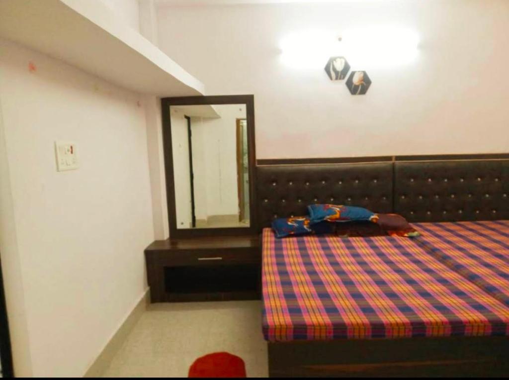a bedroom with a bed and a mirror at CHINTA HARAN REST HOUSE in Deoghar
