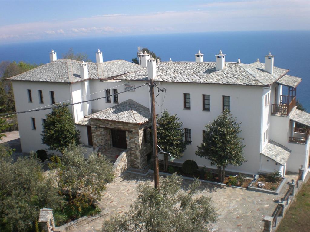 a large white house with the ocean in the background at Anatoli in Agios Dimitrios