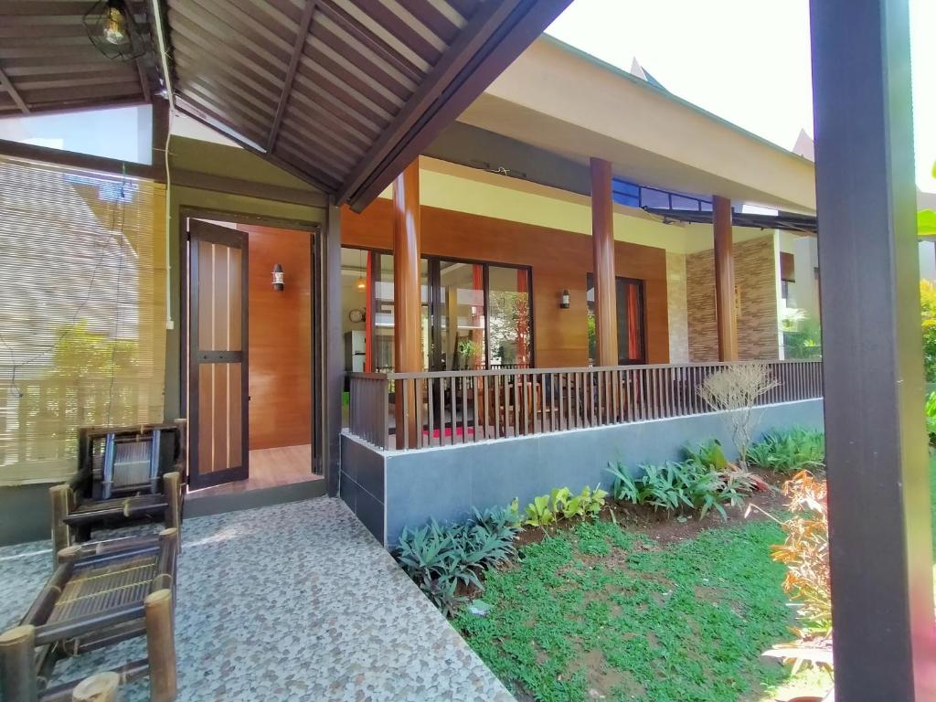 una imagen de una casa con porche en Vimala Hill villa and resort - 3 bedrooms en Bogor