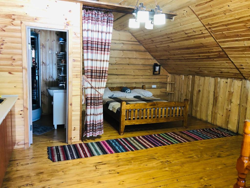 ein Schlafzimmer mit einem Bett in einer Holzhütte in der Unterkunft У Віти номер2 in Synewyrska Poljana