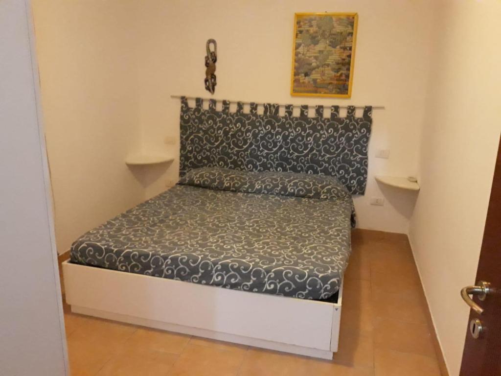 a small bed in a small room at Airport 25 min ByWalk-Big Port 10 min by bus-Bus 1 min by walk to city&beaches-Touristic port at 1 min by walk - WIFI AIR COND WASH MACHINE -4 pex 2 Rooms veranda&GARDEN-FREE PARKING-GIALLO in Olbia