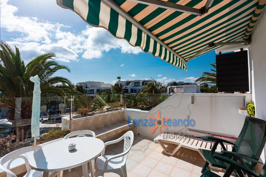 a patio with a table and chairs and an umbrella at Vivienda Vacacional Los Molinos 6205 in Costa Teguise