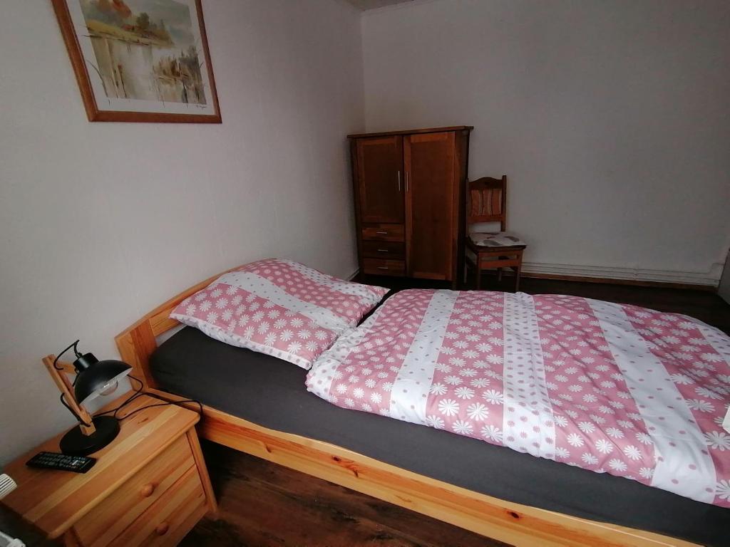 sypialnia z łóżkiem z czerwoną i białą kołdrą w obiekcie Ellen`s Pension w mieście Dobbrun
