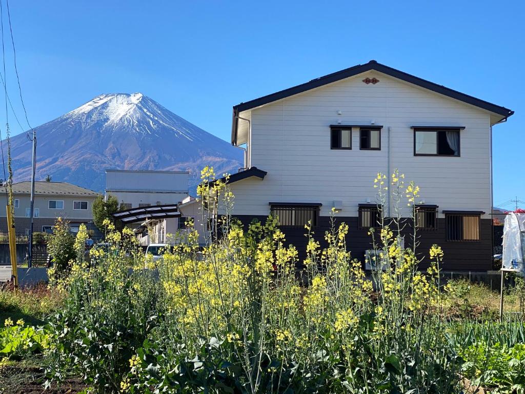 a house with a snow covered mountain in the background at LINK HOUSE in Fujiyoshida