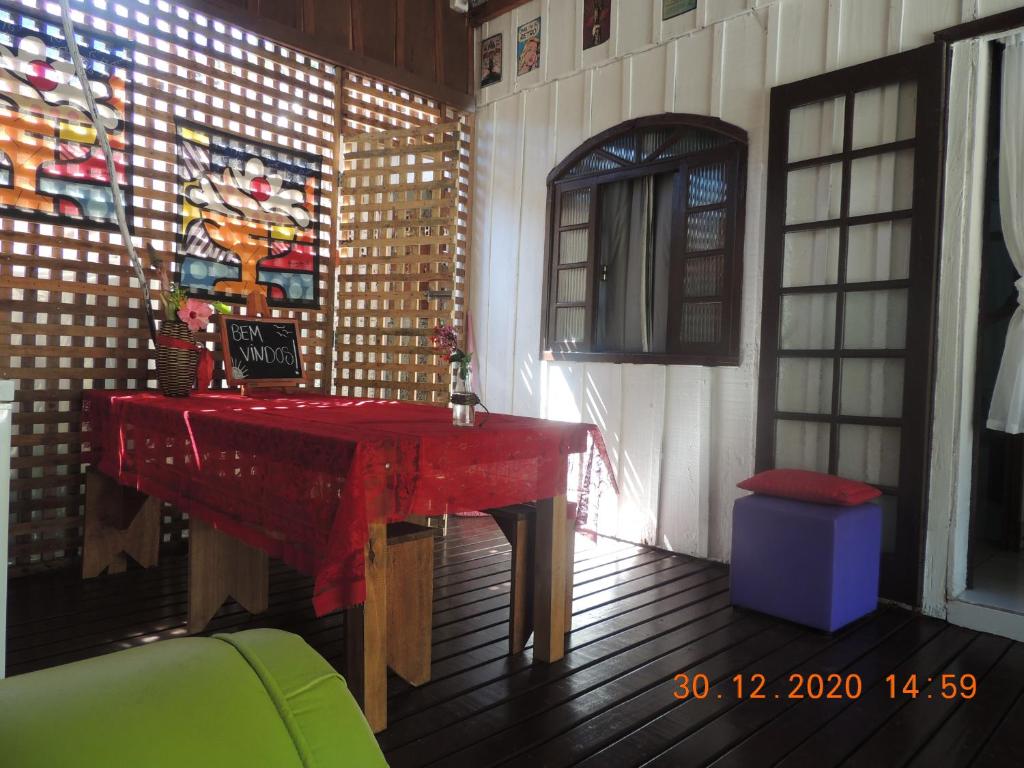 蜂蜜島的住宿－RECANTO DO SOL "Aluguel de quartos - Hospedagem Simples"，一间设有红色桌子和窗户的房间