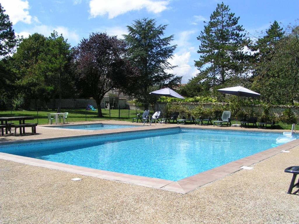 una piscina en un patio con mesas y sombrillas en Orion, In A Complex Of 7 Gites, Les Constellations, en Doeuil-sur-le-Mignon