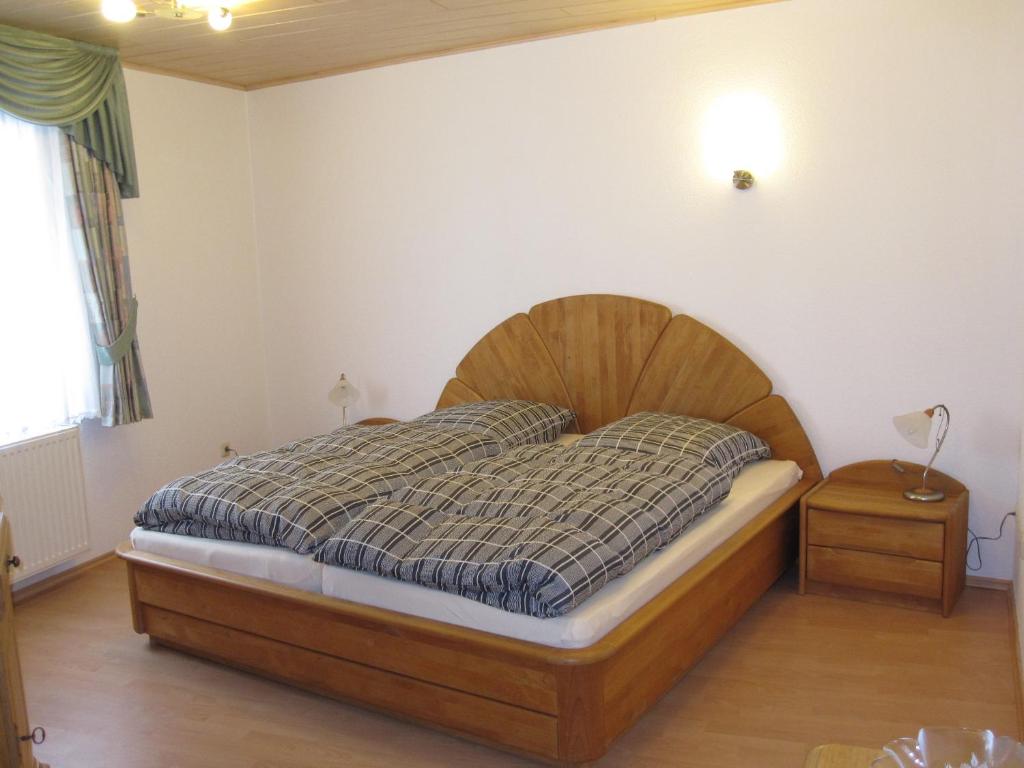 1 dormitorio con 1 cama con cabecero de madera en Ferienwohnungen - An der Kunstakademie, en Heimbach