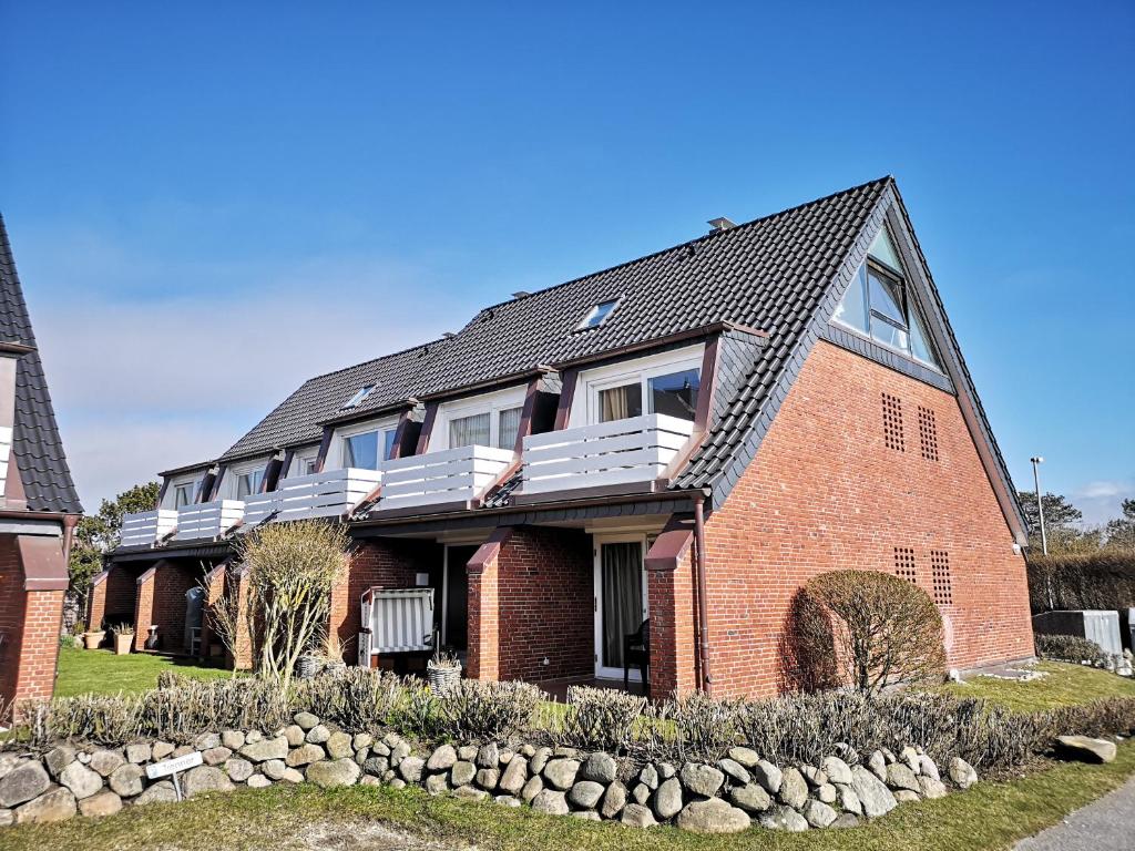 a large red brick house with a balcony at Strandnah in Wenningstedt in Wenningstedt