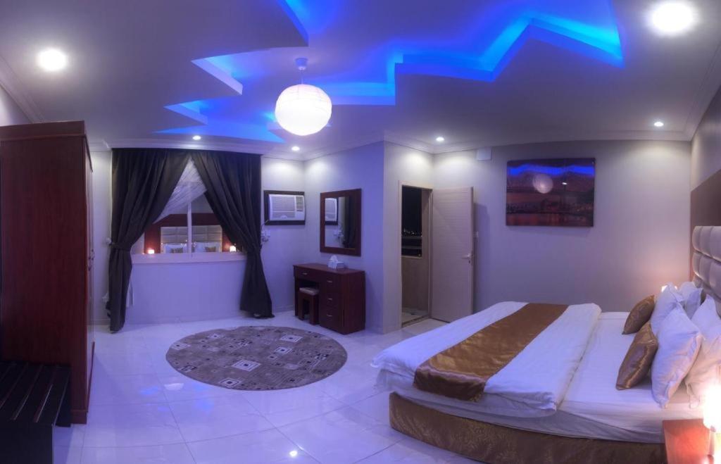 a bedroom with a bed with a blue ceiling at Al Tal Serviced Apartments in Baljurashi
