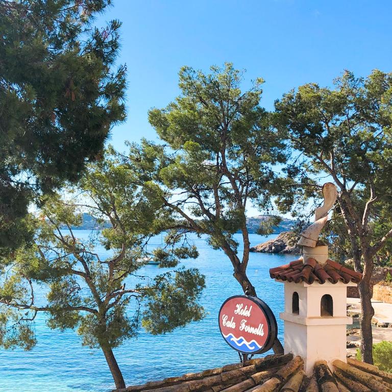 a sign on top of a building next to the water at Hotel Cala Fornells in Paguera