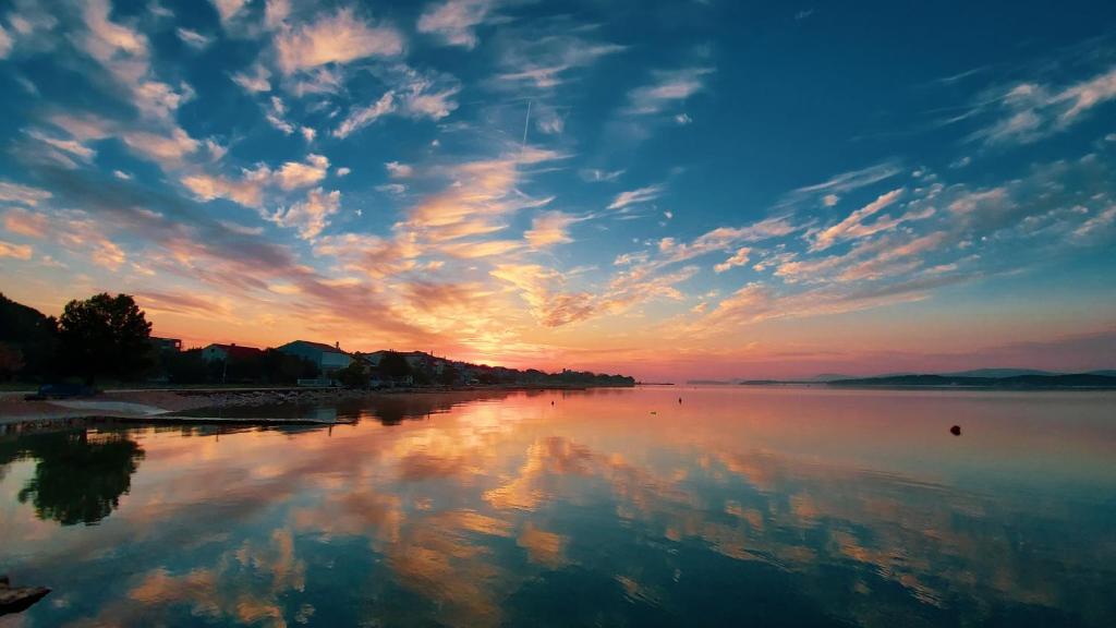 un grand volume d'eau avec un ciel nuageux dans l'établissement Holiday home - Beach house 'Amarella', à Turanj