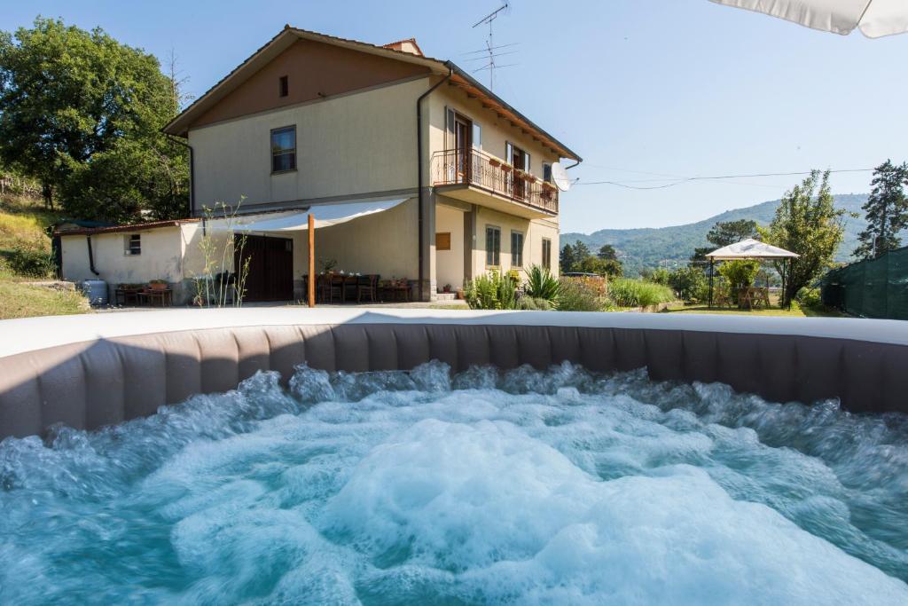 una piscina d'acqua di fronte a una casa di Il Rifugio di Amelia ad Arezzo