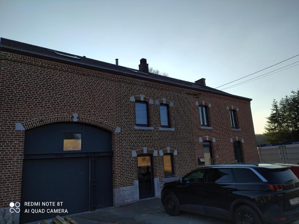 un coche negro estacionado frente a un edificio de ladrillo en Balade en amoureux au calme, en Rochefort
