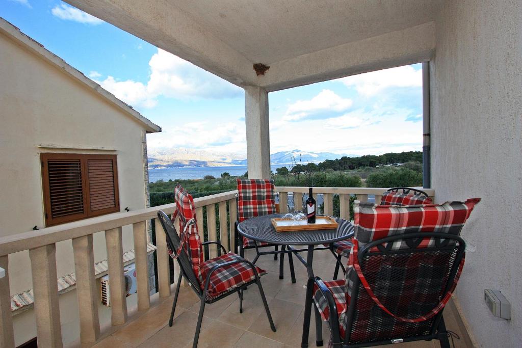 un patio con tavolo e sedie sul balcone. di Apartment Petra a Supetar (San Pietro di Brazza)