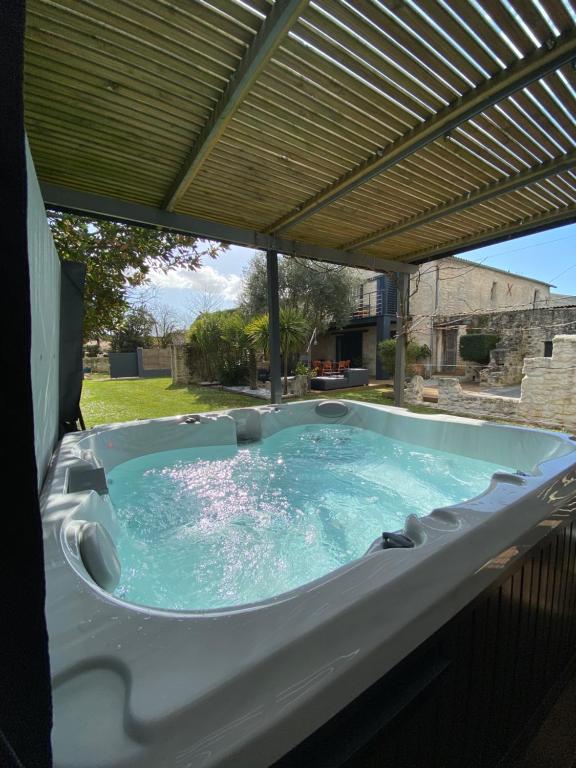 a jacuzzi tub under a pergola at Ô Chambres d'Hôtes in Le Gua