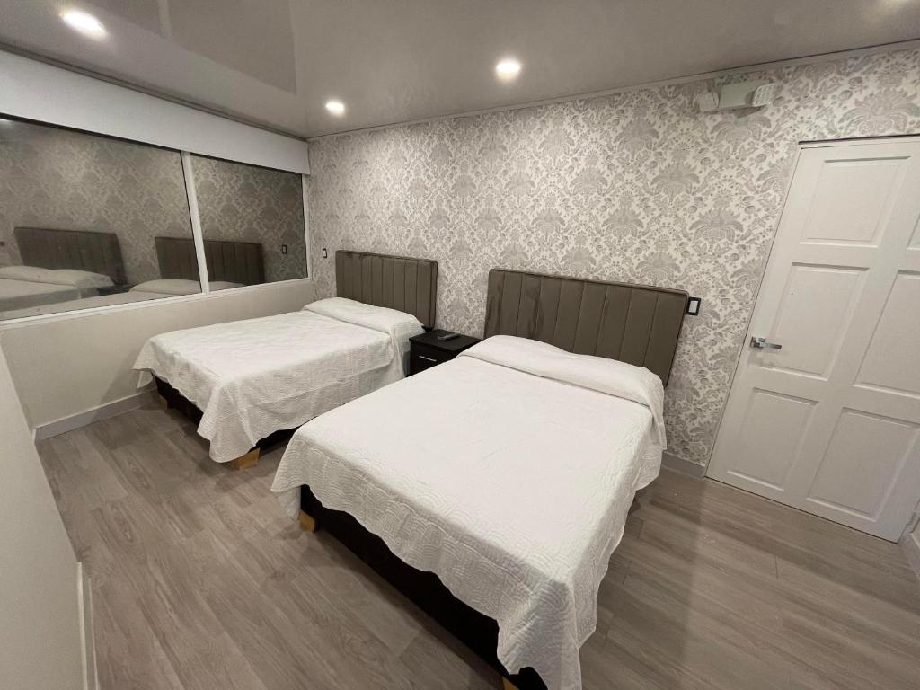 Habitación con 2 camas y espejo. en Borabora hotel, en San Andrés
