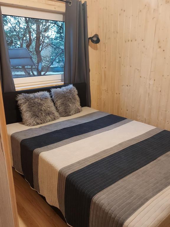 two beds in a room with a window at Domek nad stawem in Robakowo