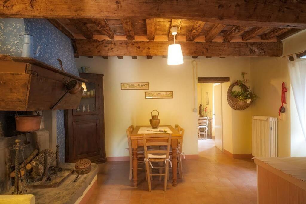 eine Küche und ein Esszimmer mit einem Tisch und einem Herd in der Unterkunft La Casina Rossa in Borgo Pace